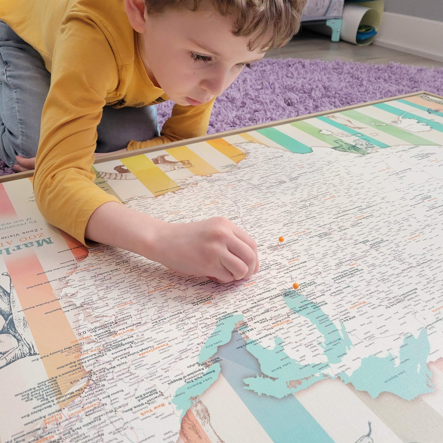 a young boy laying on a map of the world