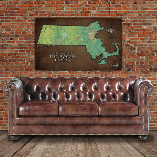 a brown leather couch sitting in front of a brick wall