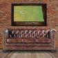 a brown leather couch sitting in front of a brick wall