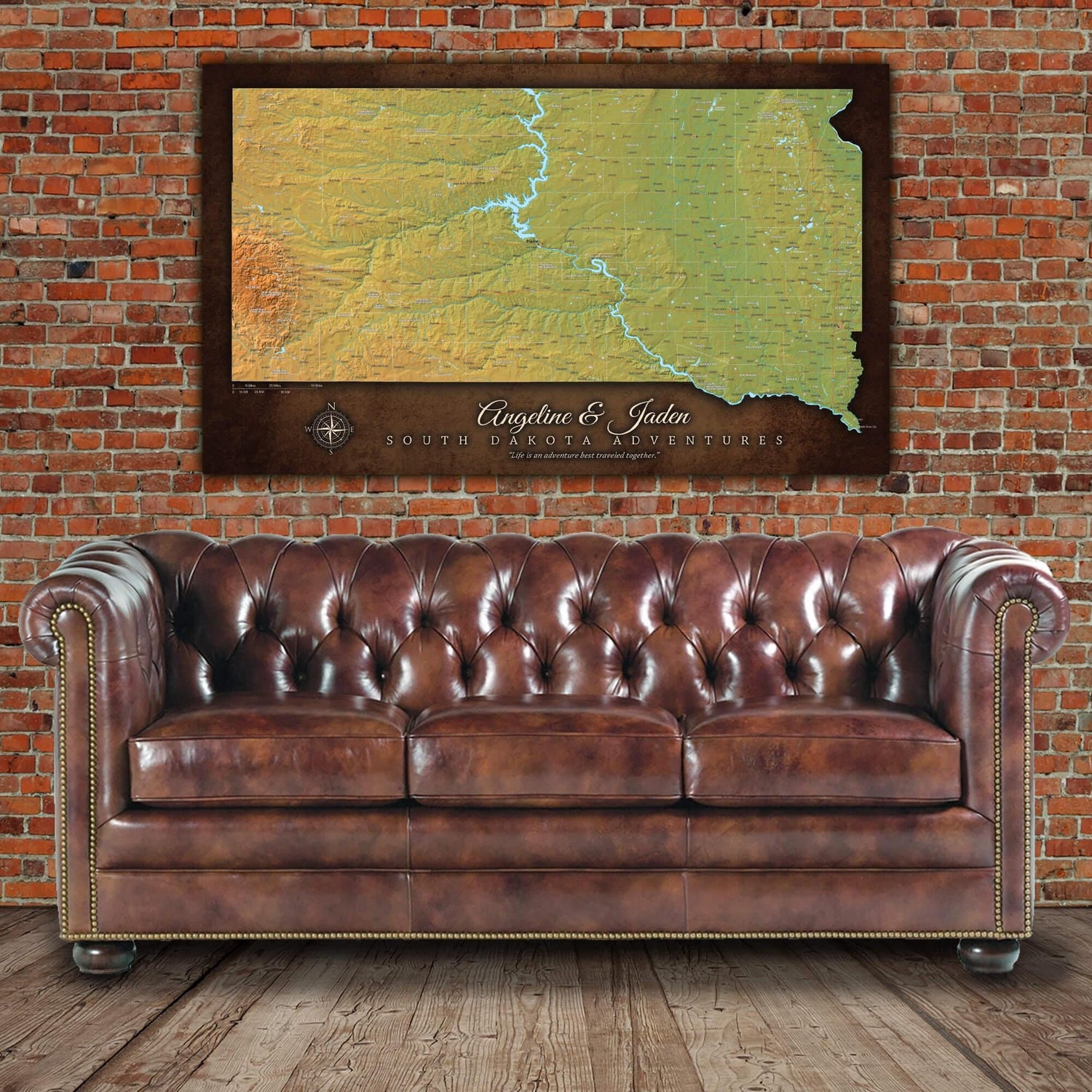 a brown leather couch sitting in front of a brick wall